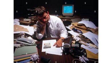 A small business owner looking stressed with a pile of paperwork