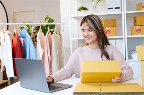 A small business owner in the UK smiling while working on a laptop, representing efficient business management.